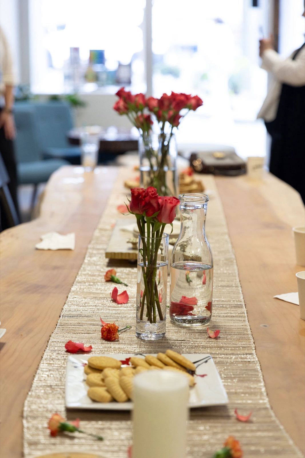 Sobar’s communal table set with red roses, candles, and treats for a gathering