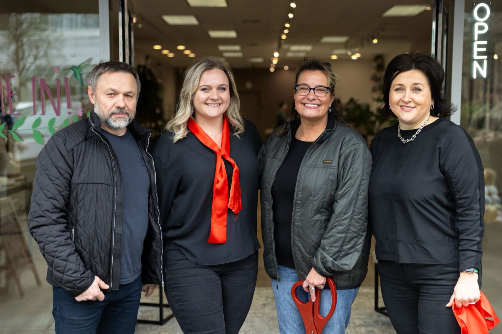 Four people celebrating Sobar’s opening outside the café with ribbon-cutting scissors